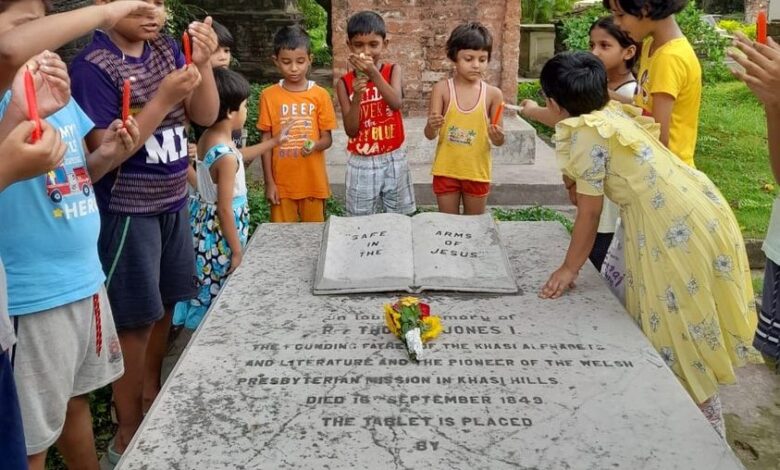 Children light candles and pay floral tribute at Thomas Jones's grave.