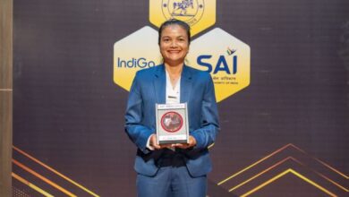 Riiohlang Dhar with the award. She is in a blue suit and smiling at the camera. Photo sourced
