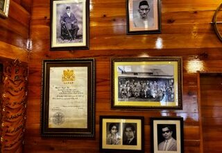 Amjad Ali and his family's memories adorn the wooden wall of the 150-year-old house in Laban. Photo by MM